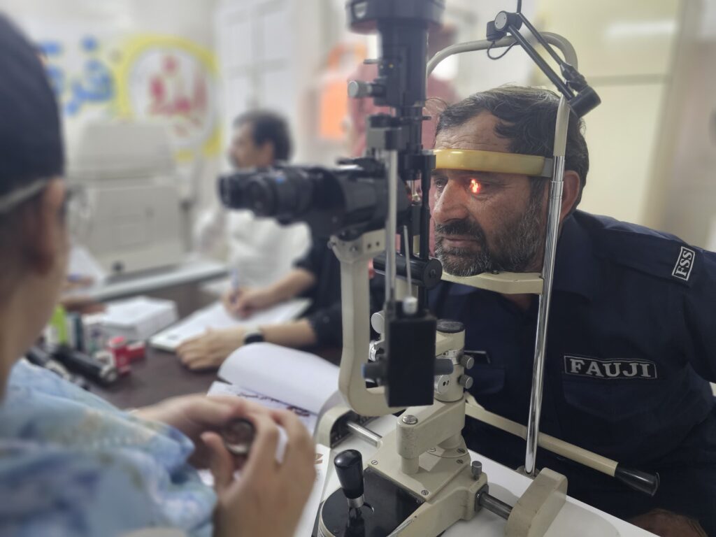 OCT Test Guide- An Aged person having an eye test before OCT test Cataract eye surgery in Wah Cantt for Poor and needy